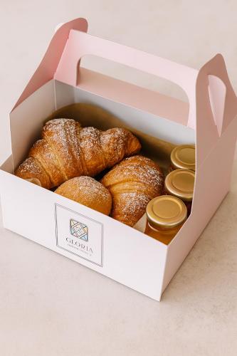 Eine Schachtel voller Croissants stand auf einem Tisch. in der Unterkunft Gloria Luxury Suites in Kallithea (Chalkidiki)
