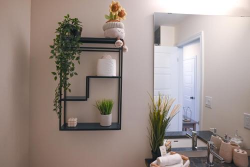ein Badezimmer mit Spiegel und Pflanzen an der Wand in der Unterkunft Modern 3Bed Home 10 Mins to Niagra Falls in Thorold