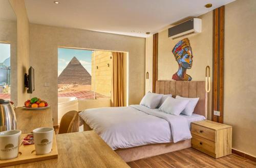 1 dormitorio con cama y vistas a las pirámides en Cleo Patra Pyramids Tower Inn, en Banī Ghālib