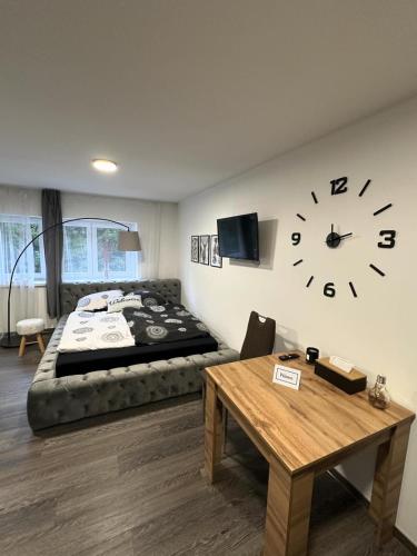 济泽罗河畔帕塞基Horský apartmán Dolní Rokytnice的卧室配有一张床,墙上挂着大钟