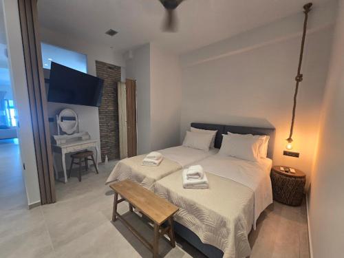 a bedroom with a bed with a bench and a table at Ilia Suites ''Paralia'' in Ilia