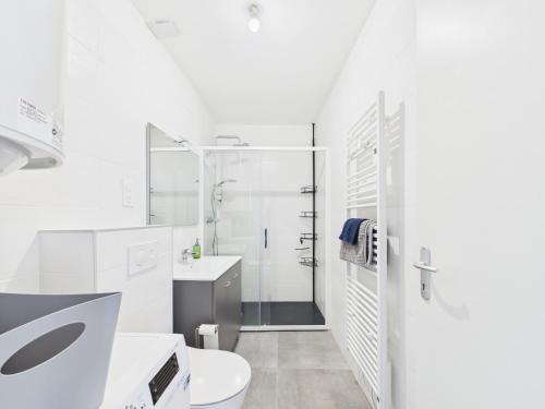 a white bathroom with a toilet and a shower at Loki Rivoli Cottage in Locquirec