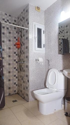 a bathroom with a toilet and a shower and a sink at Apartment 25B11 Mixta in Dakar