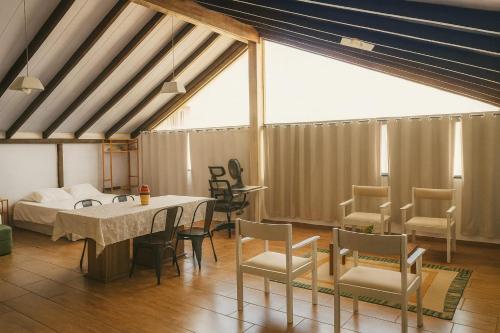 a room with a bed and a table and chairs at Pousada Morada Coqueiros in Florianópolis