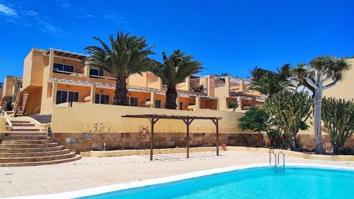 a resort with a swimming pool in front of a building at Paraíso en Fuerteventura in Costa Calma