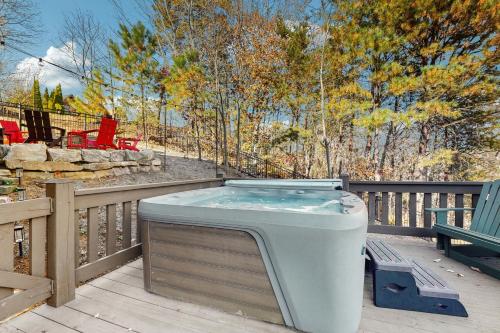 un bain à remous assis sur une terrasse à côté d'un banc dans l'établissement Boulder Ridge Cabin, à Lake Lure