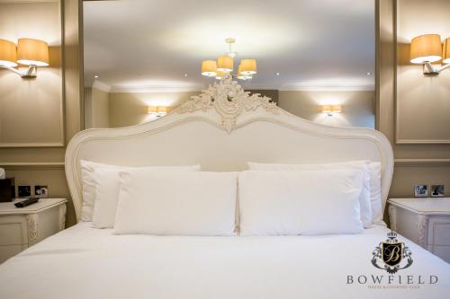 a bedroom with a white bed with white pillows at Bowfield Hotel and Spa in Howwood