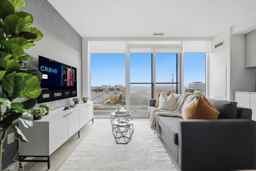 a living room with a couch and a flat screen tv at Stylish 2BR Retreat Parking & Sleeps 6 in Toronto