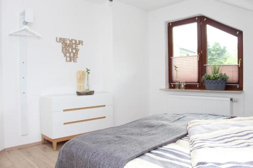 ein Schlafzimmer mit einem Bett, einer Kommode und einem Fenster in der Unterkunft Ferienhaus Lirum Larum Löffelstiel in Hemfurth-Edersee