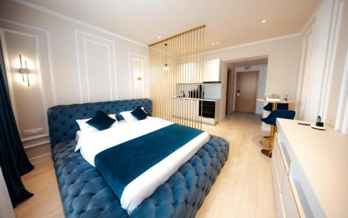 a bedroom with a blue bed with a blue couch at YamaLuxe Luxury Apartments - București in Bucharest