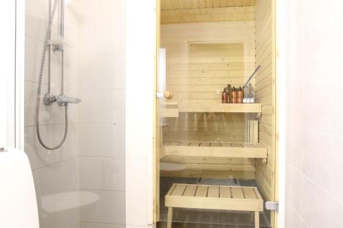 a bathroom with a shower with a bench in it at Arctic Aurora Suite Rovaniemi in Rovaniemi
