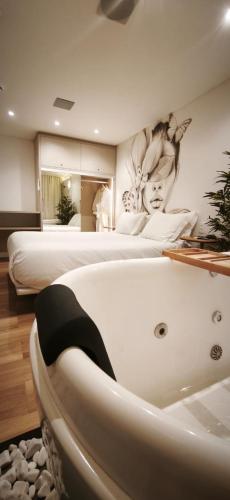 a room with two beds and a bath tub at Up Hotel Boutique in Bombinhas