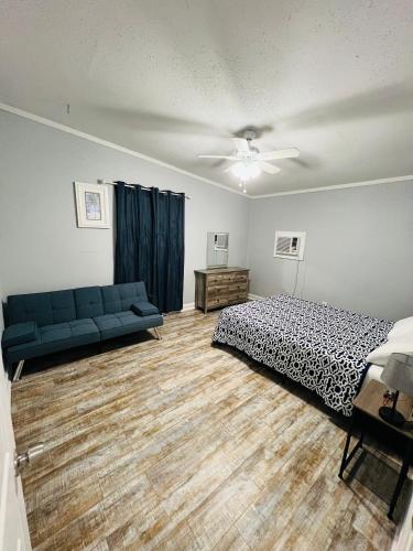 a bedroom with a bed and a blue couch at Northeast Investments LLC in Gulfport