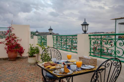 a table with food and orange juice on a balcony at Riad Dar Bahja - More Than a Stay in Fès