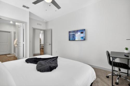 a white bedroom with a bed and a desk at Cozy 2 BR Apt |King Bed |Pool |Gym| Close to Mayo in Jacksonville