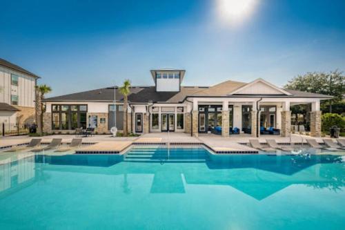 a large swimming pool in front of a house at Cozy 2 BR Apt |King Bed |Pool |Gym| Close to Mayo in Jacksonville