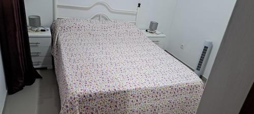 Ribeira GrandeCasa Flor Apartment的一间卧室配有一张床上的鲜花毯子