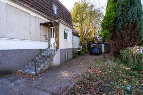 a house with a staircase next to a driveway at Ferienwohnungen am Gellershagenpark 2 in Braksiek