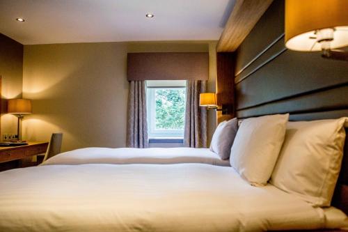 a hotel room with two beds and a window at Bowfield Hotel and Spa in Howwood