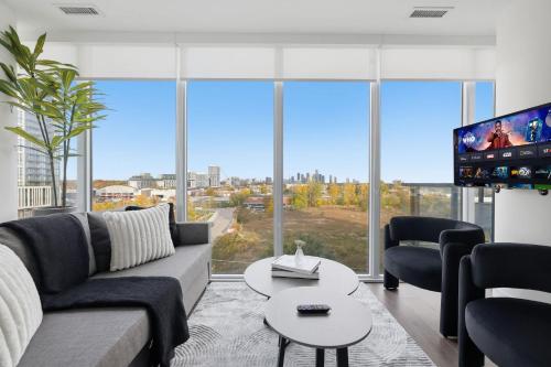 a living room with a couch and a tv at Modern 3BR Condo Sleeps 8 with Floor-to-Ceiling Views in Toronto
