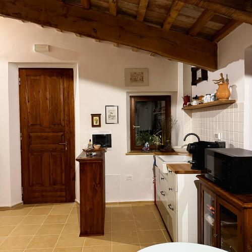 - une cuisine avec un évier et une porte en bois dans l'établissement Agriturismo Al Vicinale, à Genga