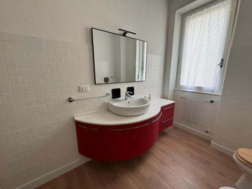 a bathroom with a red sink and a mirror at Residence Le Tre Chiocciole piano dello scoiattolo in Sondalo