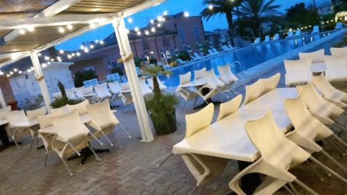 un gruppo di tavoli e sedie bianchi su un tetto di Al Borgo Village a Pietra Ligure