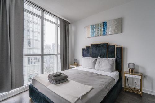 a bedroom with a large bed with a large window at Downtown Toronto luxury condos in Toronto