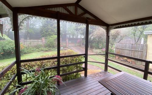 eine abgeschirmte Veranda mit Gartenblick in der Unterkunft Cabin & Cottage Kaapsehoop in Kaapsehoop