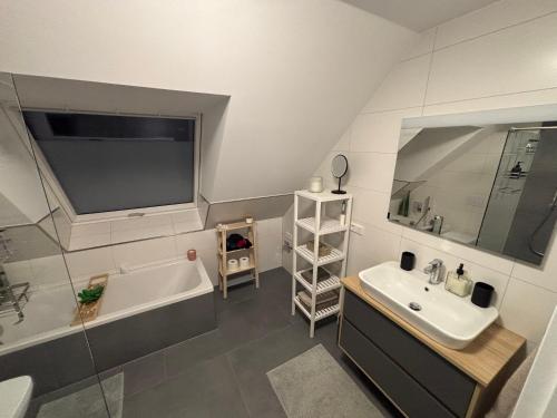 a bathroom with a tub and a sink and a bath tub at Luxuriöse Maisonette Wohnung mit Whirlpool und Weitblick im Kurviertel von Bad Salzuflen in Bad Salzuflen