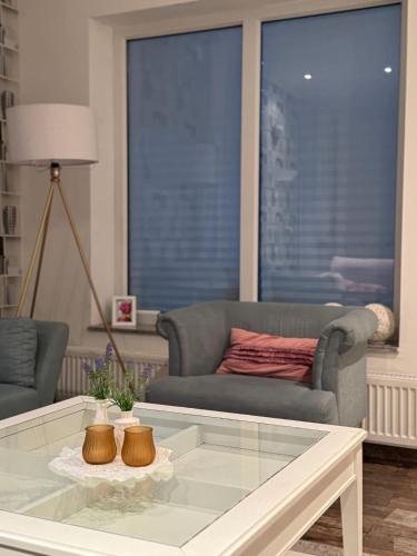 ein Wohnzimmer mit einer Couch und einem Glastisch in der Unterkunft Themenzimmer Mediterrana Nähe Hauptbahnhof in Duisburg