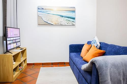 a living room with a blue couch and a tv at Depas Waicura s in Loreto