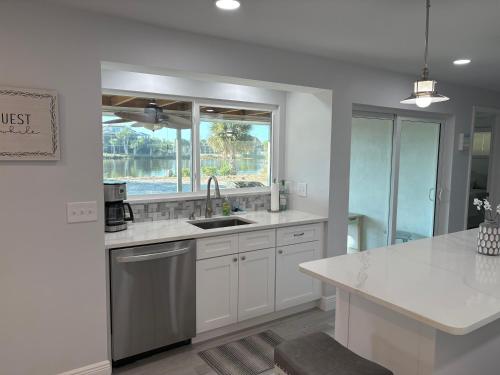 een witte keuken met een wastafel en een raam bij Tranquil Tides in Sanibel Island