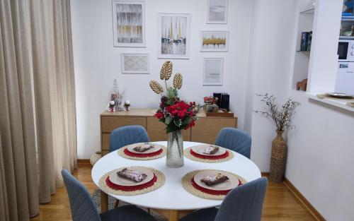 Una mesa blanca con un jarrón de flores. en BeoCity 011, en Novi Beograd