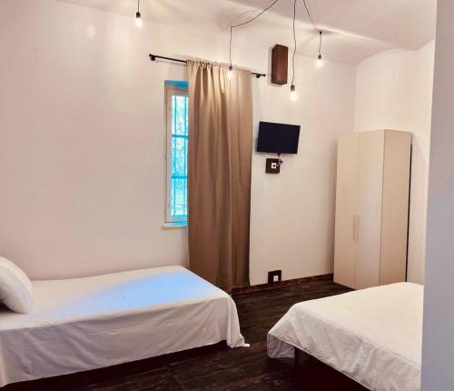 a bedroom with two beds and a window at La Locanda della Mandria 2 in Venaria Reale