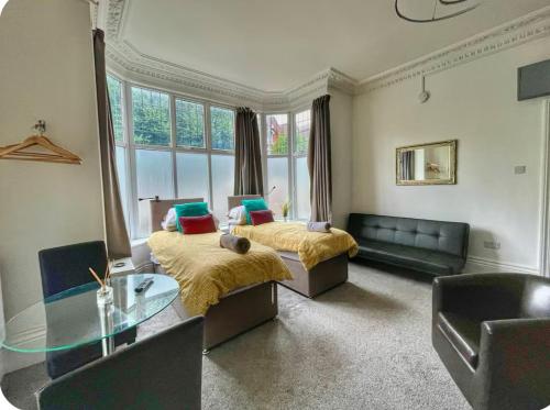 a living room with two beds and a glass table at 1st 4 Tennants in Portsmouth