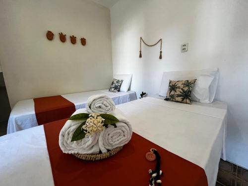 a room with two beds with towels on them at Vilare Pousada in Morro de São Paulo