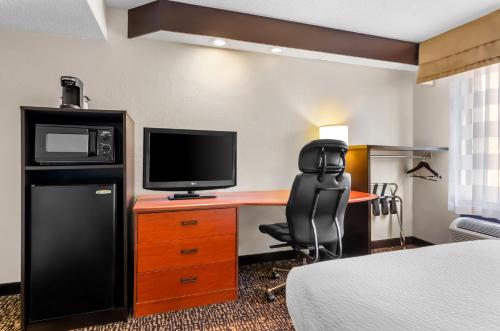 a hotel room with a desk with a television and a chair at Sleep Inn Beaver- Beckley in Beaver
