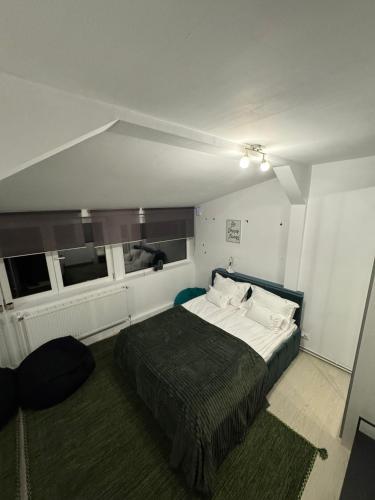a bedroom with a bed and two windows at Bucharest Residence in Bucharest