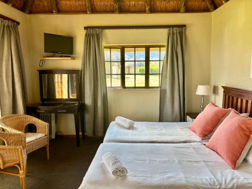 a bedroom with two beds and a window at Windmill Farm in Bergville