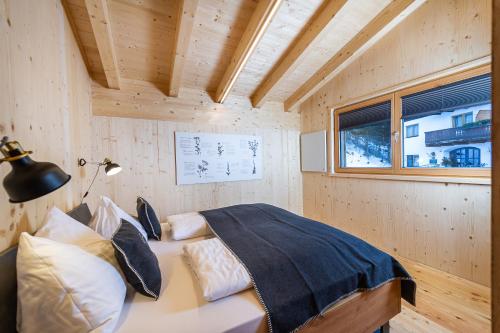 a bedroom with a bed in a wooden room at Ferienhaus Blauer Vogel - kostenfreie Saunanutzung in Prägraten