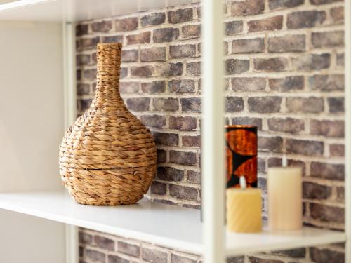 a vase sitting on a shelf next to a brick wall at Sfeervolle Studio - Privéterras & Vloerverkoeling - Achterhoek in Almen