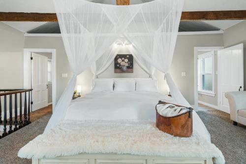 a bedroom with a white bed with a canopy at Luxurious 1875 centrally located Canton Akron home, large primary BR & sunset view in Uniontown