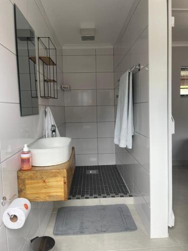 a white bathroom with a sink and a mirror at Sysie Cottage in Sedgefield