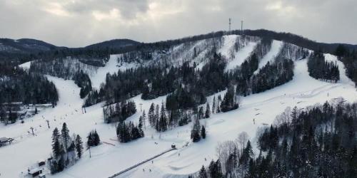 a ski slope with people skiing down a snow covered mountain at La Passion #204 - Loft with private balcony and view in Sainte-Lucie-de-Doncaster