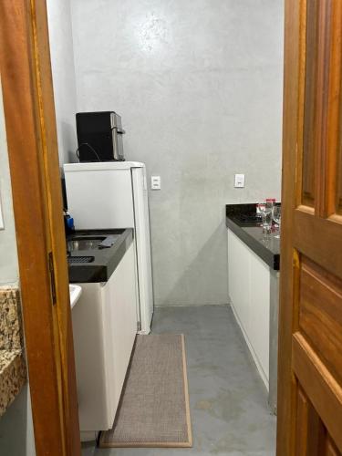 a small kitchen with a refrigerator and a microwave at Studio 4 - Solteiro in Aracruz