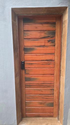 a wooden door in a room with a wall at Suite La Bela Vista in Angra dos Reis