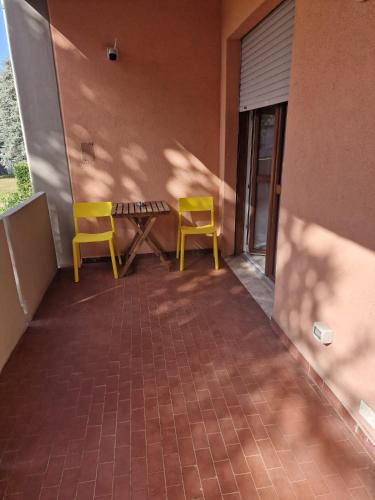 two yellow chairs and a table on a balcony at Nyx Lilura Seriate in Seriate