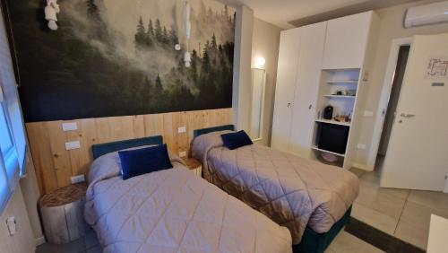 Un dormitorio con dos camas y un cuadro en la pared. en Nyx Lilura Seriate, en Seriate