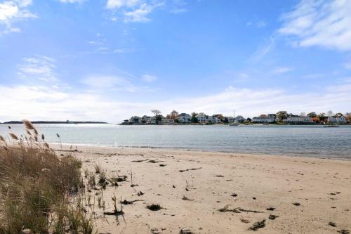 una playa de arena con casas en el fondo en Waterfront Private Beach Gorgeous Views, en Hyannis